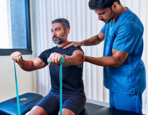 Firefly A Physiotherapist Assisting A Patient With A Shoulder Rehabilitation Exercise Using Resistan 13 Physiotherapy Toronto